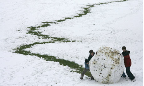 Young-boys-roll-a-giant-snowball.jpg